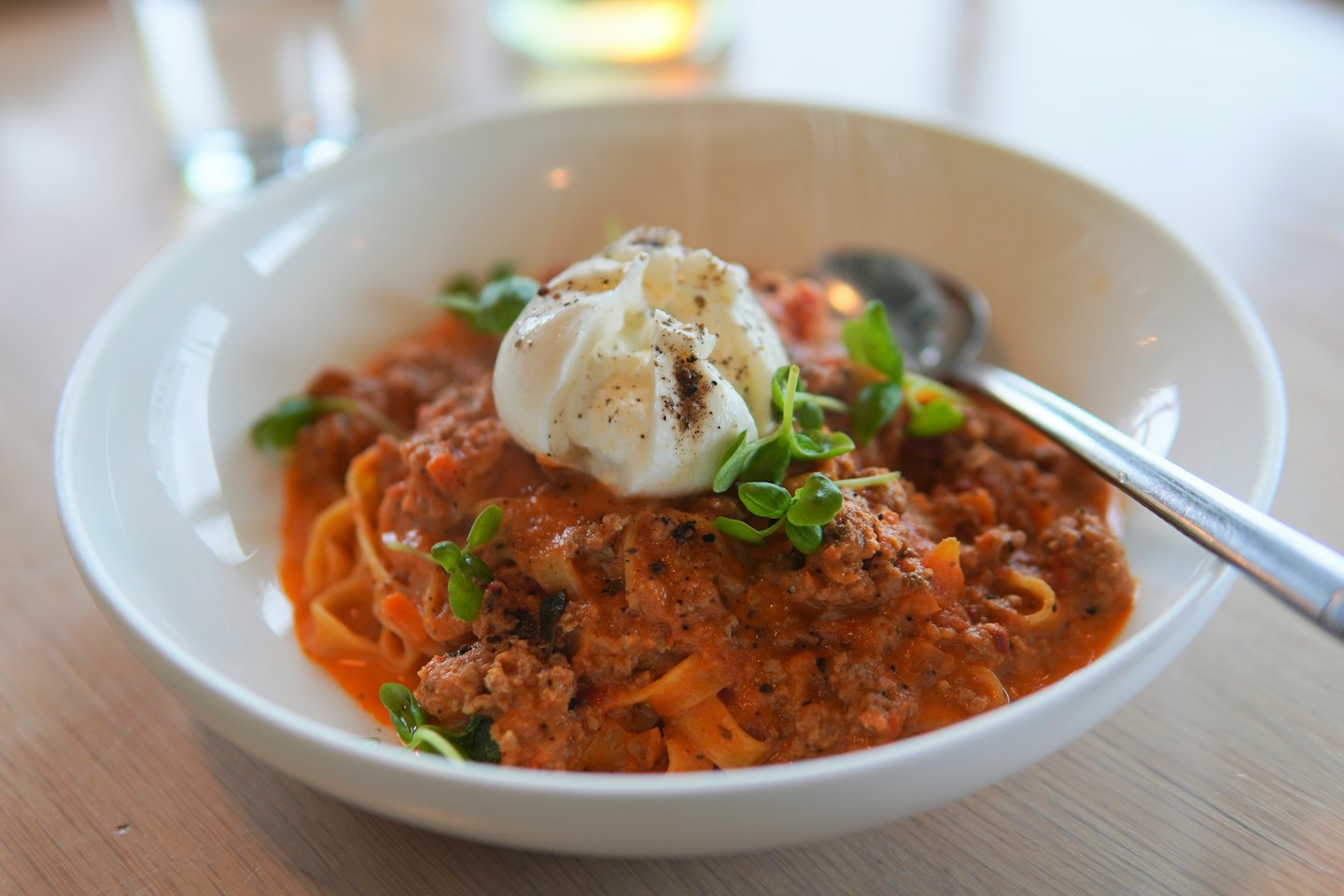 Pasta with meat sauce and cheese served in a bowl.